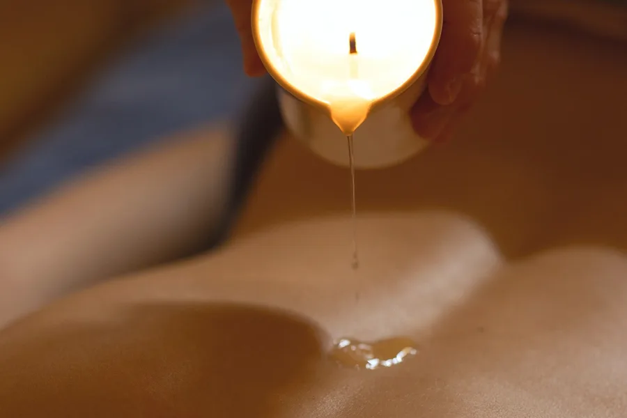 Massage mit warmem Aromaöl bei Kerzenlicht